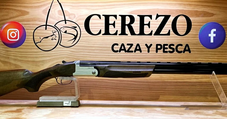 Escopeta deportiva expuesta bajo el rótulo de Cerezo Caza y Pesca